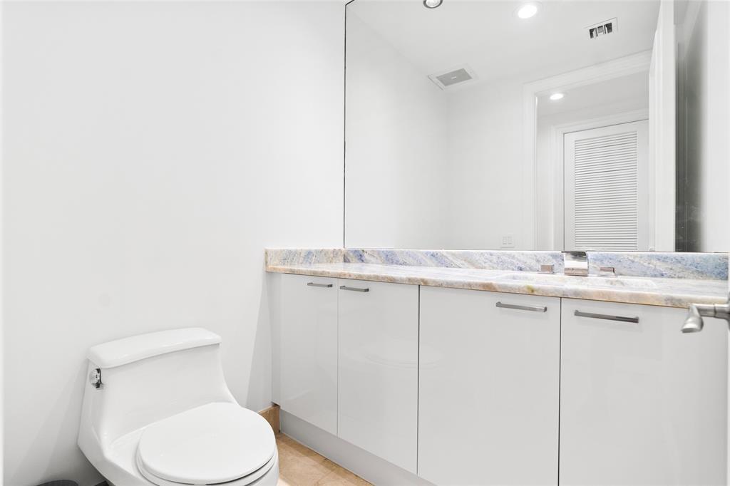 701 Southeast 21st Avenue, Unit 109 Deerfield Beach, FL 33441 - Photo 21 of 34 a bathroom with a granite countertop toilet sink and mirror