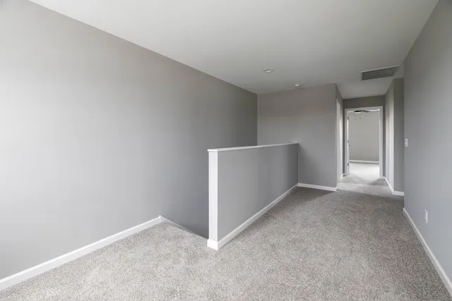 a view of an empty room with window and closet area