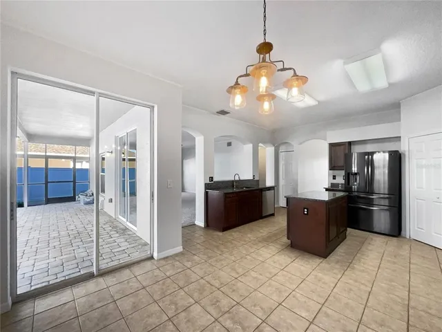 a large kitchen with stainless steel appliances granite countertop a refrigerator and a sink