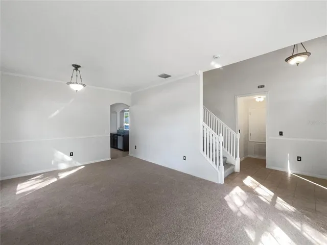 a view of empty room with stairs and a window