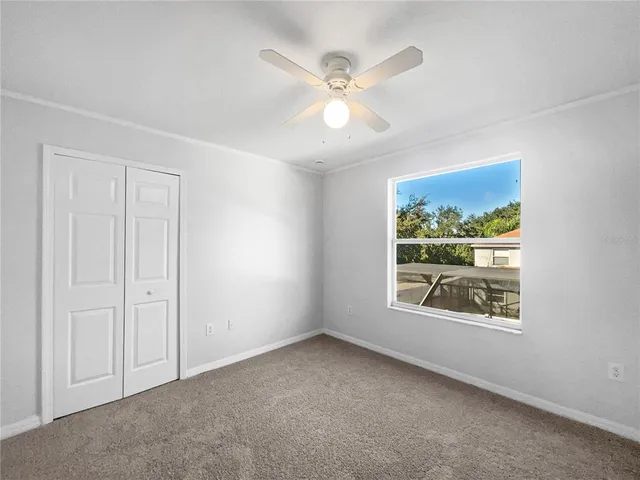 an empty room with windows and fan