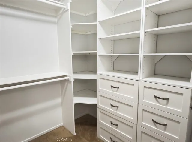 a view of walk in closet with empty racks