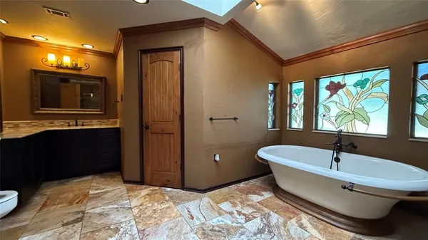 a bathroom with a granite countertop sink and a bathtub