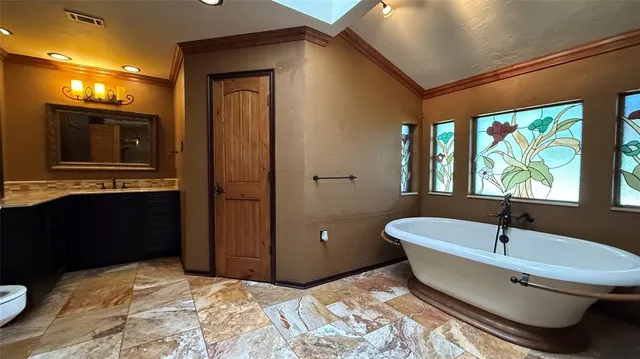 a bathroom with a granite countertop sink and a bathtub