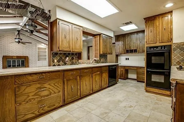a large kitchen with stainless steel appliances granite countertop a sink and cabinets