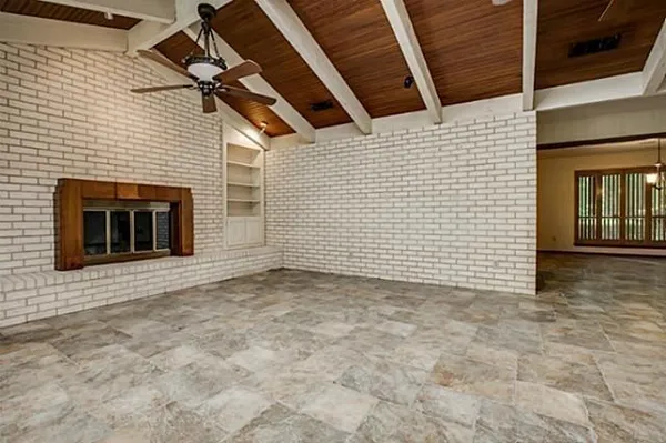 a view of a livingroom with a chandelier fan and windows