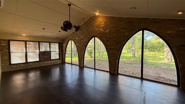 a view of empty room with a fireplace and wooden floor