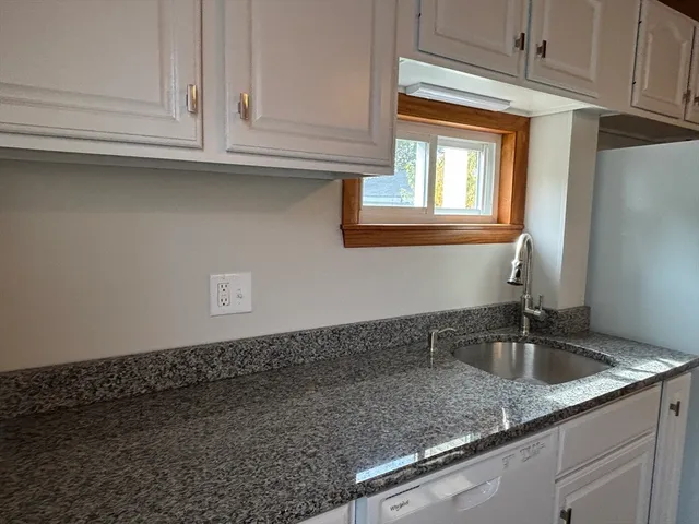 a kitchen with granite countertop a sink and cabinets