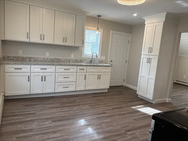 a kitchen with granite countertop wooden cabinets and a sink