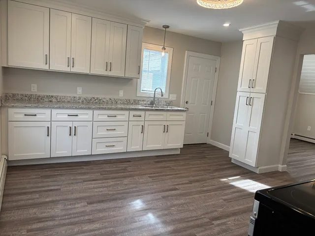 a kitchen with granite countertop wooden cabinets and a sink