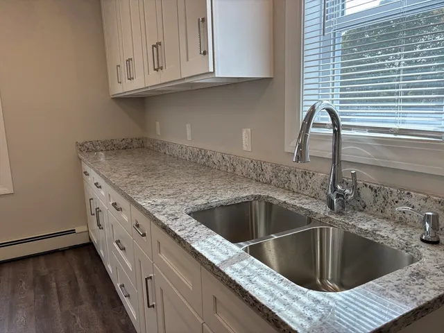 a kitchen with granite countertop a sink and a stove