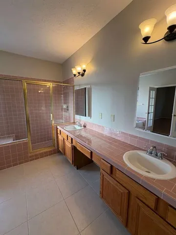 a bathroom with double vanity and a mirror