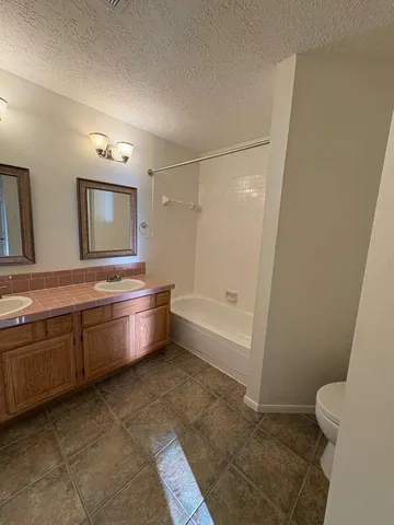 a bathroom with a tub sink toilet and mirror
