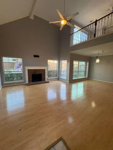 an empty room with floor to ceiling windows and fireplace