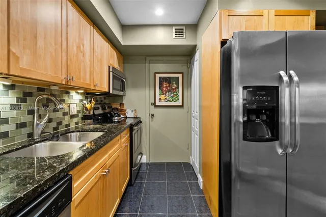 a kitchen with stainless steel appliances granite countertop a sink and a cabinets