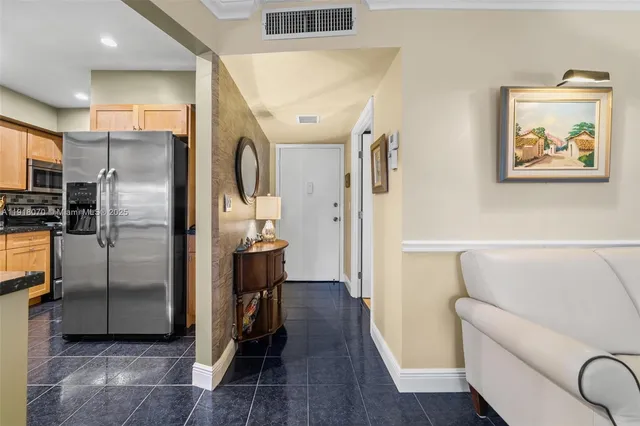 a living room with stainless steel appliances kitchen island granite countertop a couch and wooden floor
