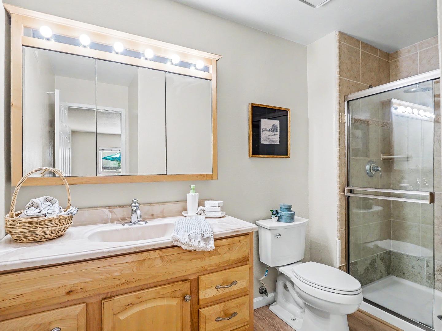 6455 Kensington Place Gilroy, CA 95020 - Photo 18 of 32 a bathroom with a granite countertop sink mirror vanity and toilet