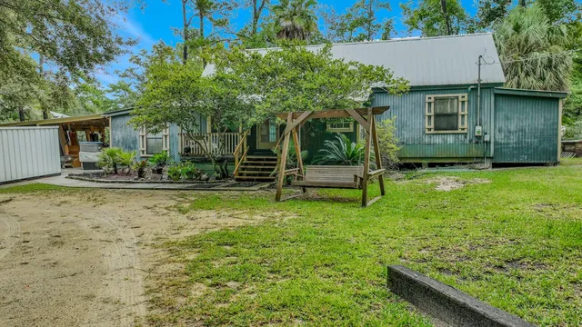 a view of a house with backyard and sitting area