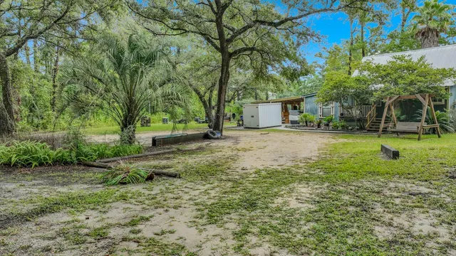 a view of a house with backyard and sitting area