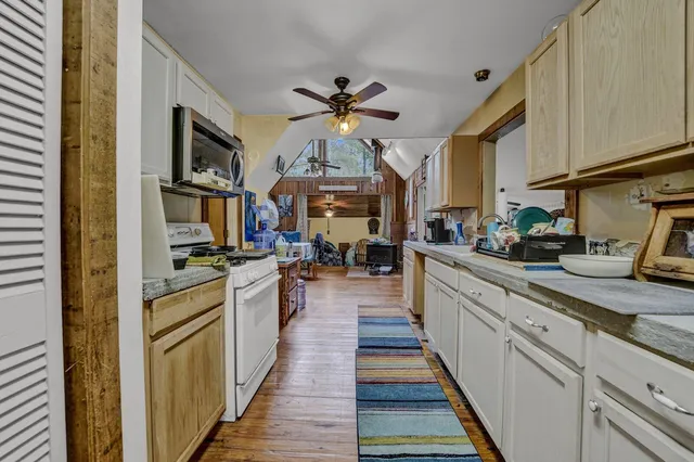 a kitchen with stainless steel appliances granite countertop lots of counter top space and wooden floor