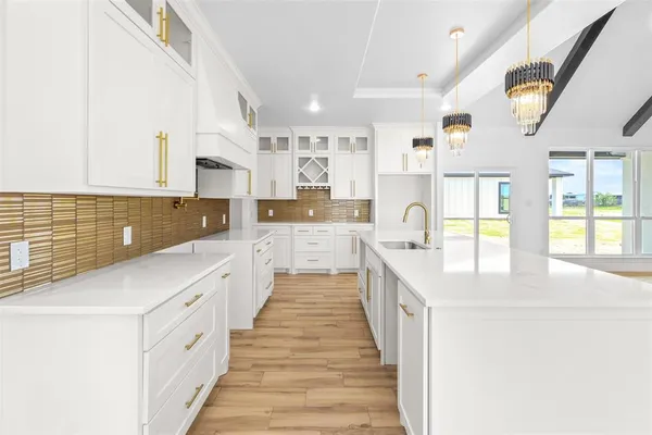 a large kitchen with stainless steel appliances kitchen island a large counter tops and a window