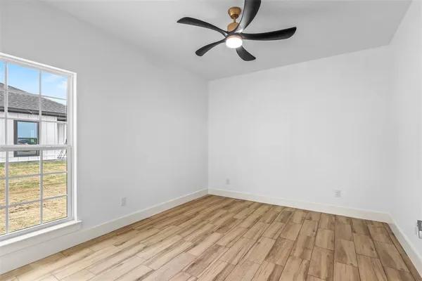 an empty room with a window and a ceiling fan
