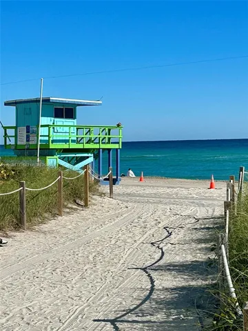 a view of a tennis ground with large trees