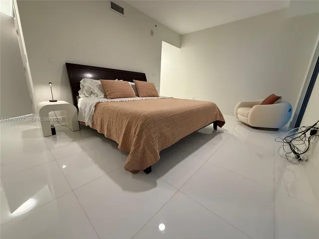 a bedroom with a bed and a chair