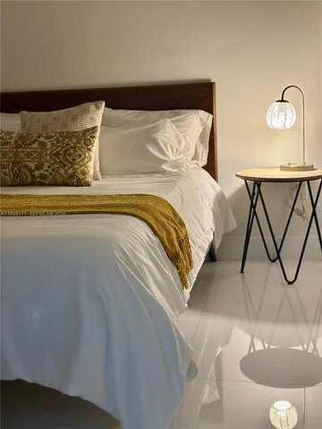 a bed sitting in a bedroom next to a lamp