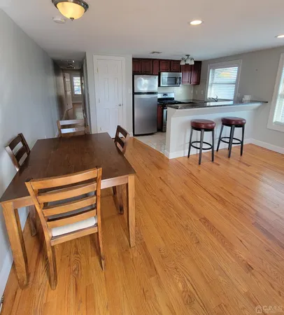 a living room with a table chairs and kitchen view