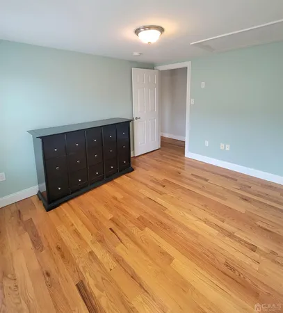 a view of an empty room and window with wooden floor