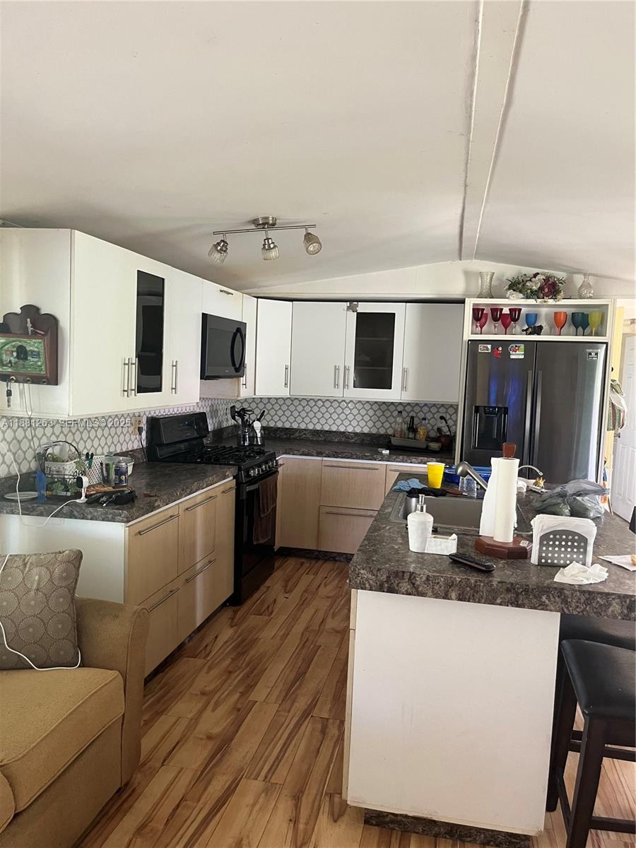 105 Farrer Road Frostproof, FL 33843 - Photo 19 of 48 a kitchen with granite countertop a sink a counter top space cabinets stainless steel appliances and cabinets