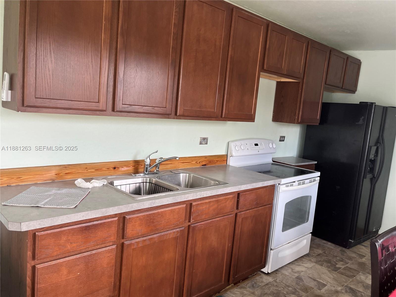 105 Farrer Road Frostproof, FL 33843 - Photo 41 of 48 a kitchen with stainless steel appliances granite countertop a sink stove and refrigerator