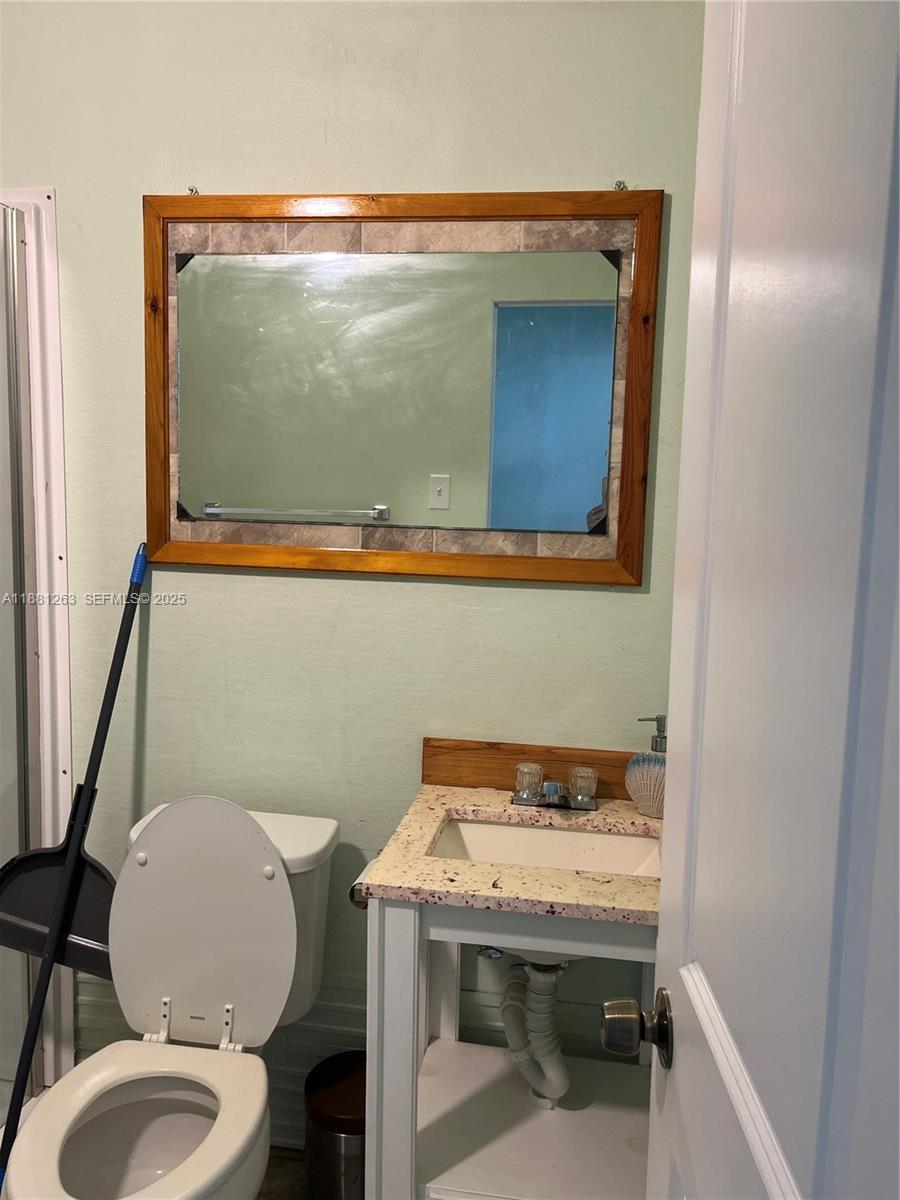 105 Farrer Road Frostproof, FL 33843 - Photo 43 of 48 a bathroom with a toilet a sink and mirror