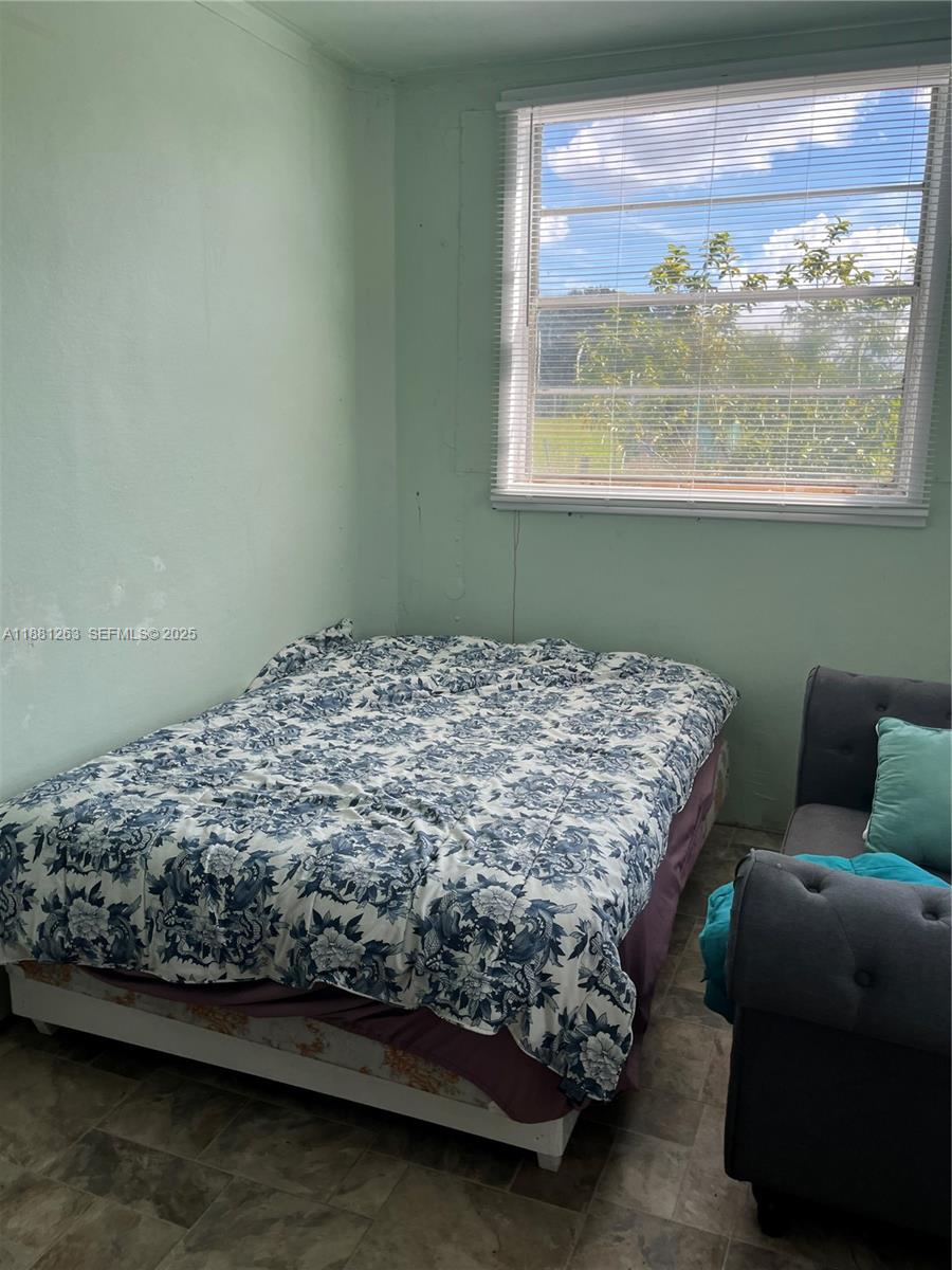 105 Farrer Road Frostproof, FL 33843 - Photo 47 of 48 a bed sitting in a bedroom next to a window