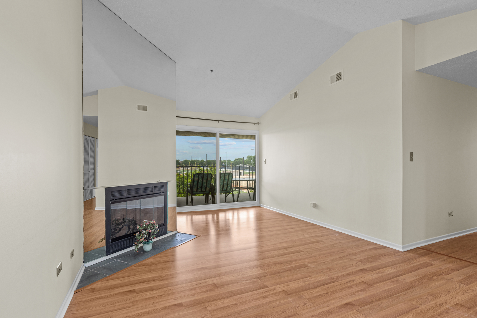 720 Weidner Road, Unit 302 Buffalo Grove, IL 60089 - Photo 6 of 27 an empty room with wooden floor and fireplace