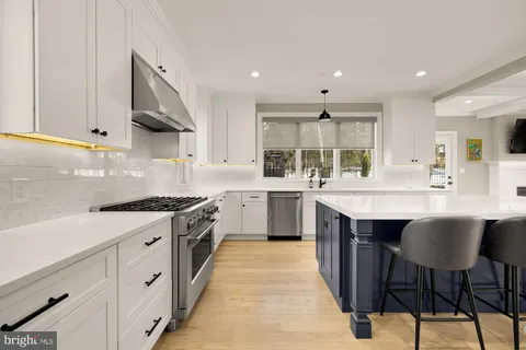 a kitchen with stainless steel appliances a sink stove and cabinets
