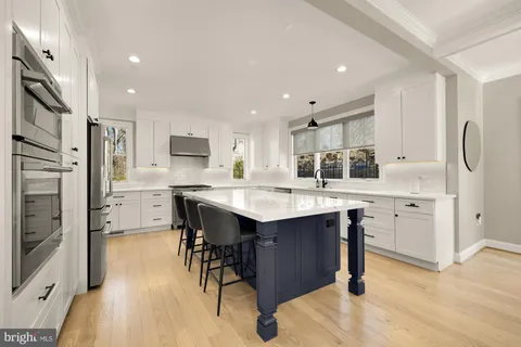 a kitchen with stainless steel appliances granite countertop a refrigerator a sink dishwasher and a stove with wooden floor