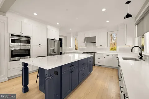 a kitchen with kitchen island a sink appliances and cabinets