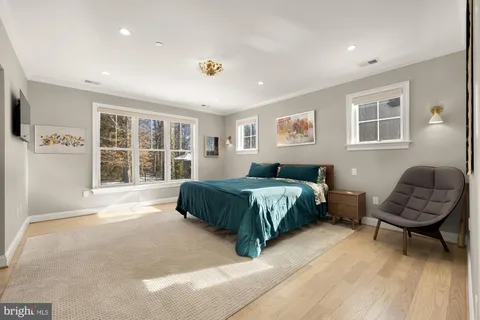 a view of a room with wooden floor mirror and windows