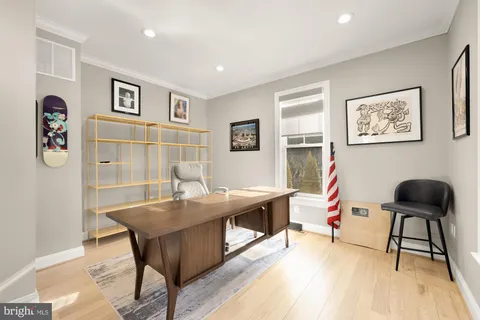 a view of a workspace with furniture and wooden floor