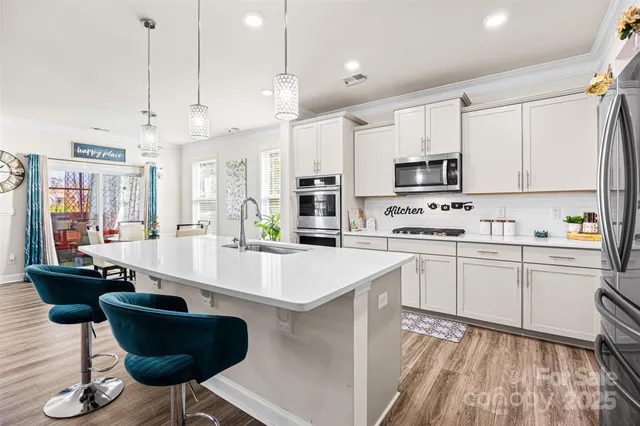 a kitchen with stainless steel appliances kitchen island granite countertop a sink and cabinets