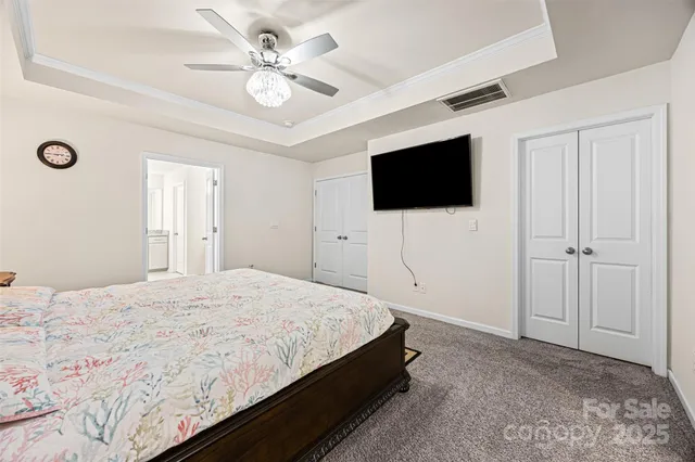 a spacious bedroom with a bed and a flat screen tv