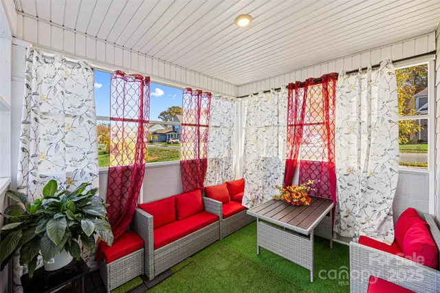 a living room with furniture and a floor to ceiling window
