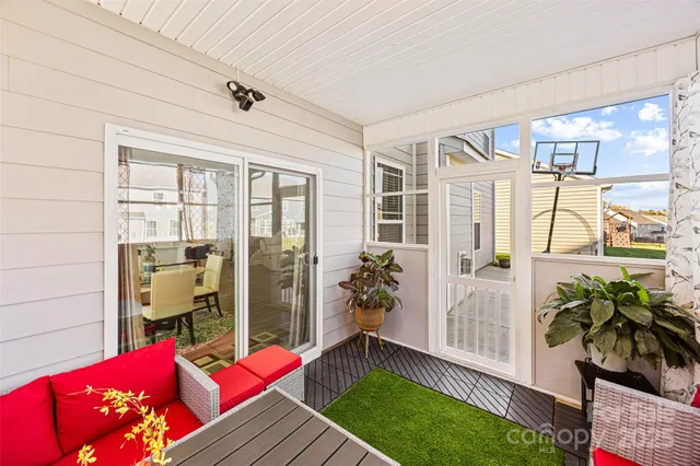 a living room with furniture floor to ceiling window and potted plants