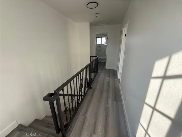a view of a hallway with wooden floor and staircase