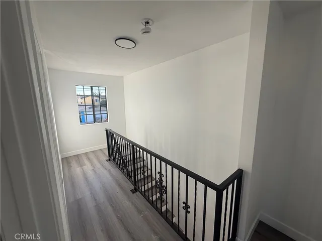 a view of a hallway with wooden floor and stairs