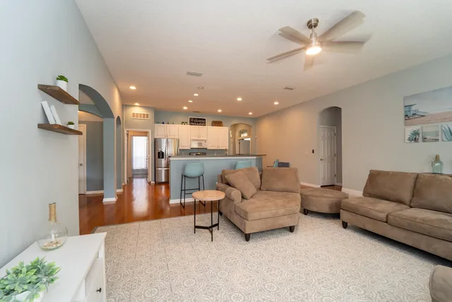 a living room with furniture and a view of kitchen