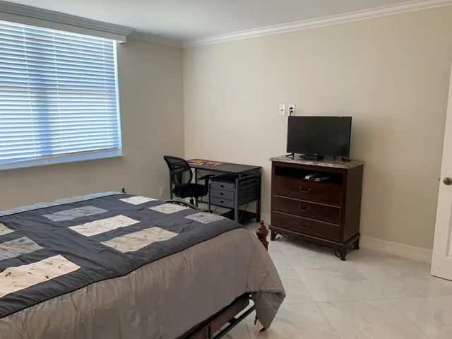 a bedroom with a bed and a television