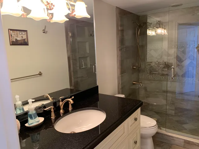 a bathroom with a sink a toilet and shower